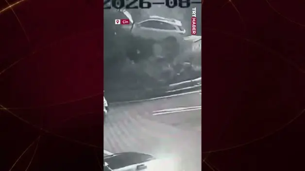 Çin'de akılalmaz kaza: Kaldırıma çarpan otomobil ağaçla trafo arasında asılı kaldı!
