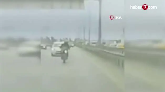 Köprüden sarkan reklam afişi motosikletliyi yola savurdu